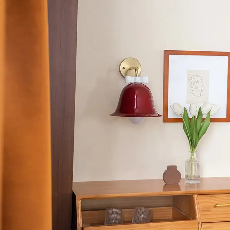 Red bell-shaped decorbites bowknot bell wall lamp with gold mounting plate and white bow accent for bedroom decor