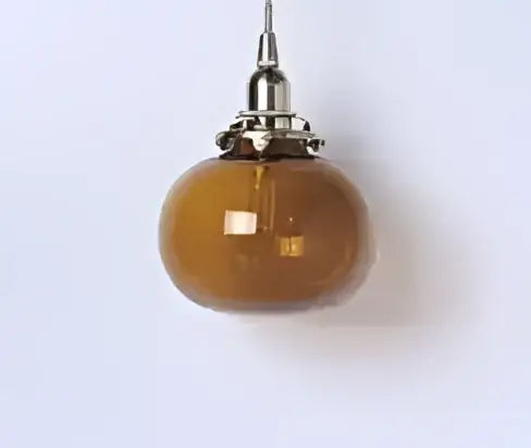 Amber-colored glass pendant light with metallic fixture complementing decorbites blue glass pendant lights for dining room