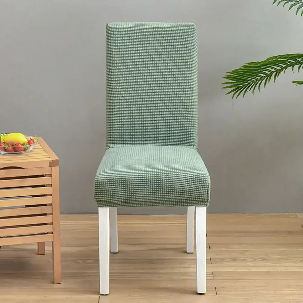 A mint green textured stretch chair cover with a subtle grid pattern by decorbites blue quilted chair cover protector
