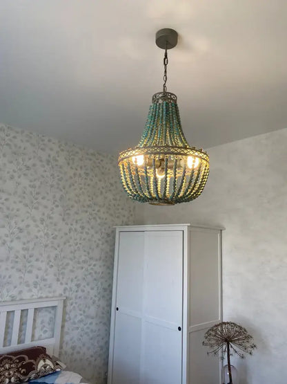 Teal blue wood beads pendant light with a woven metal frame and warm glowing bulbs for bedroom decorbites blue wood beads