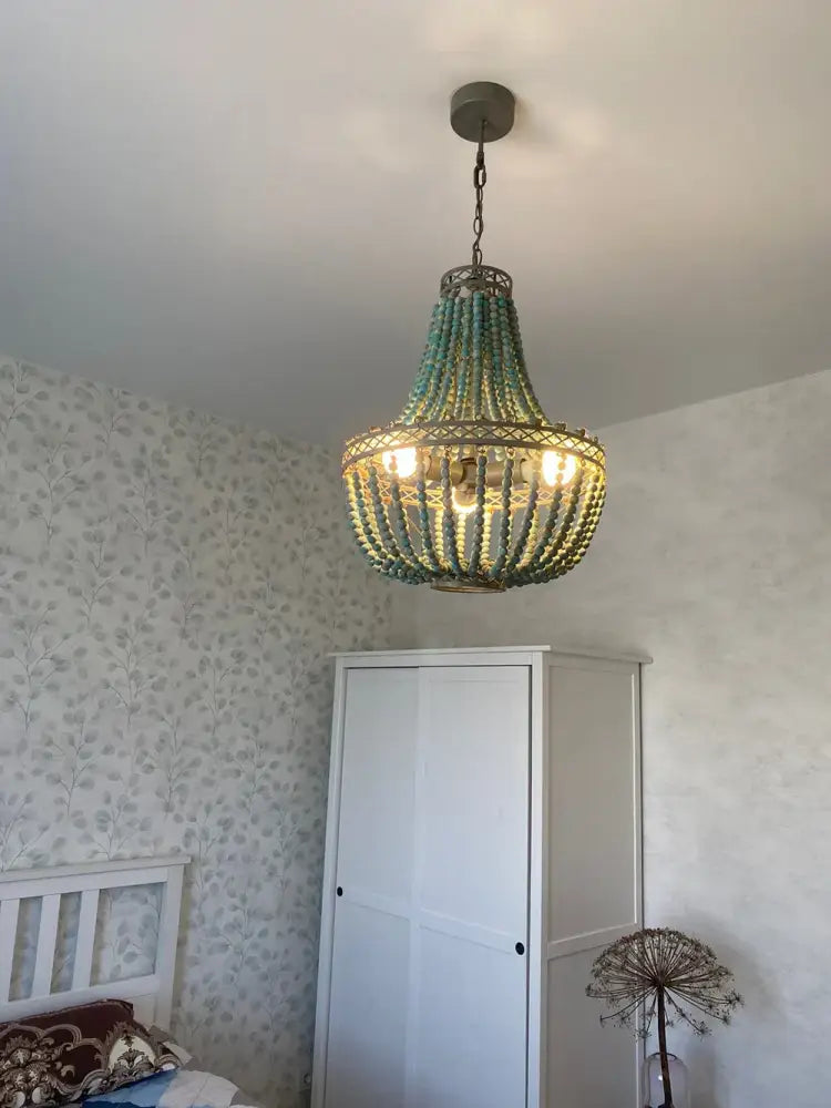 Teal blue wood beads pendant light with a woven metal frame and warm glowing bulbs for bedroom decorbites blue wood beads