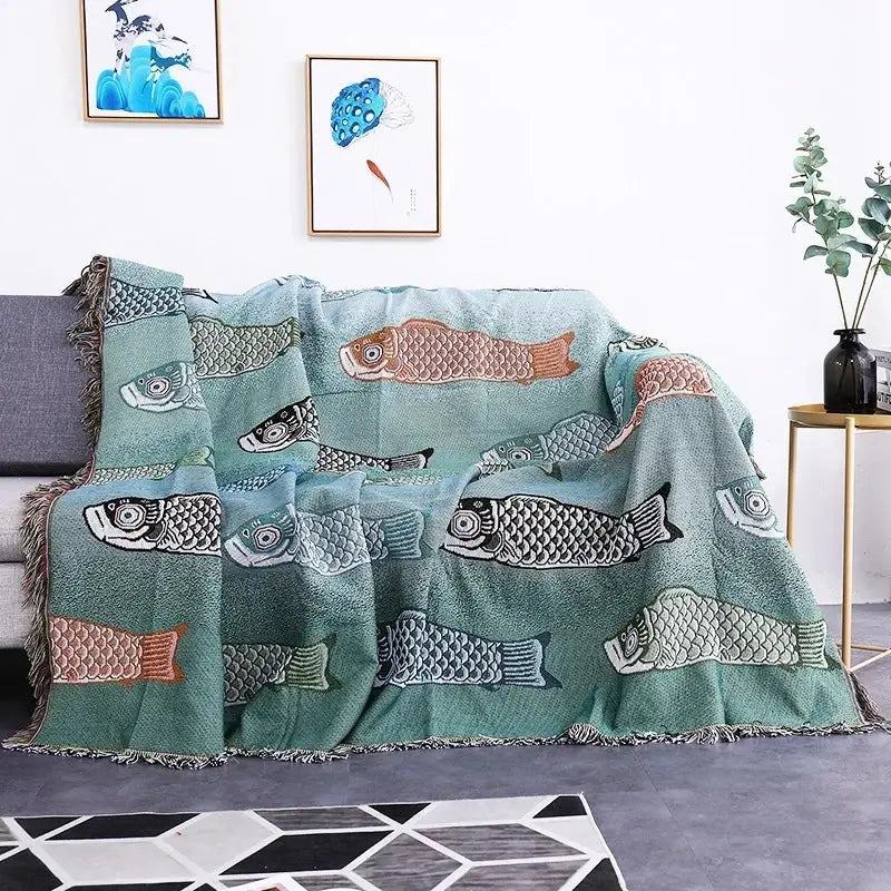 Teal sofa blanket with dustproof butterfly carp pattern featuring embroidered fish in brown gray and black with fringed edges