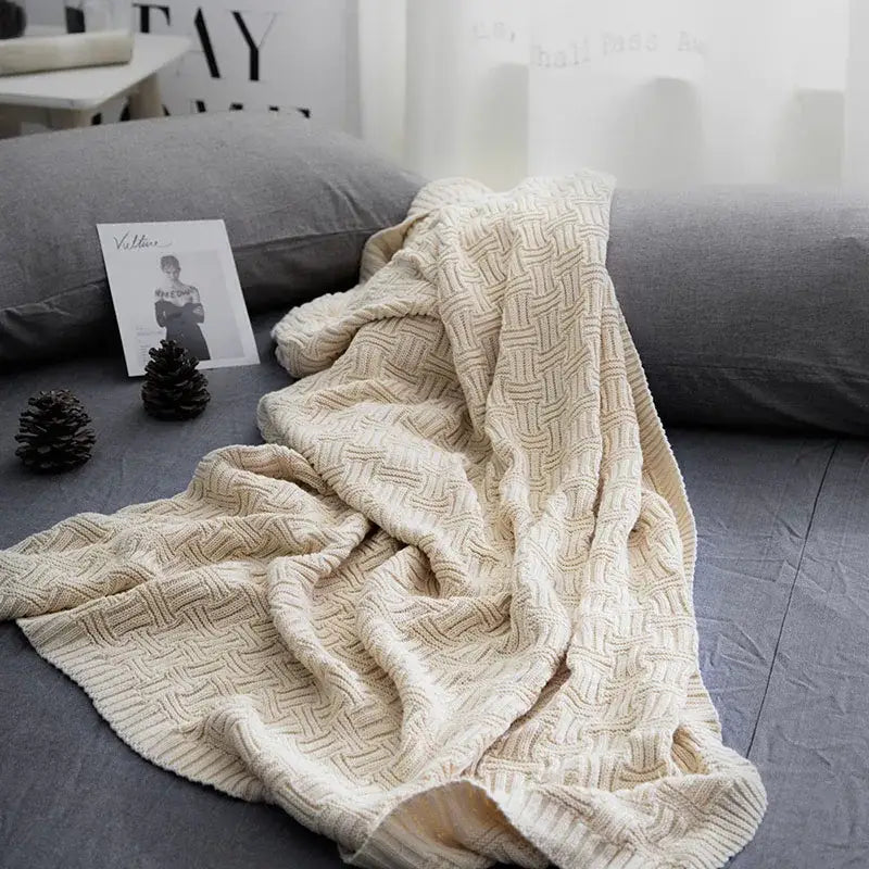 Cream-colored knitted throw blanket with textured woven pattern from decorbites cozy jacquard living room throw collection
