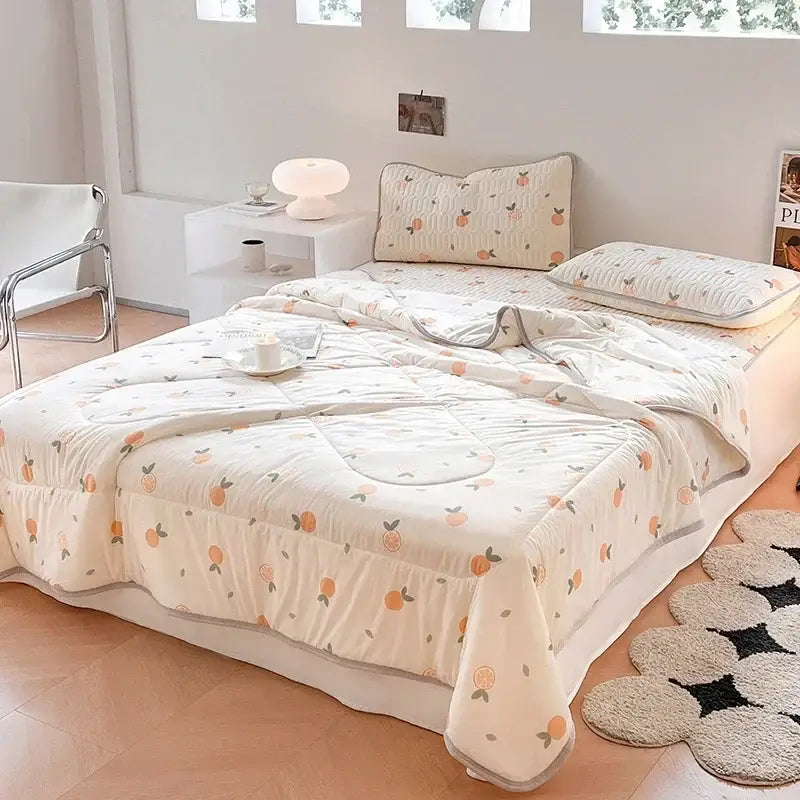 Cream-colored quilted blanket set with peach-orange citrus pattern and gray piping for decorbites cool summer use
