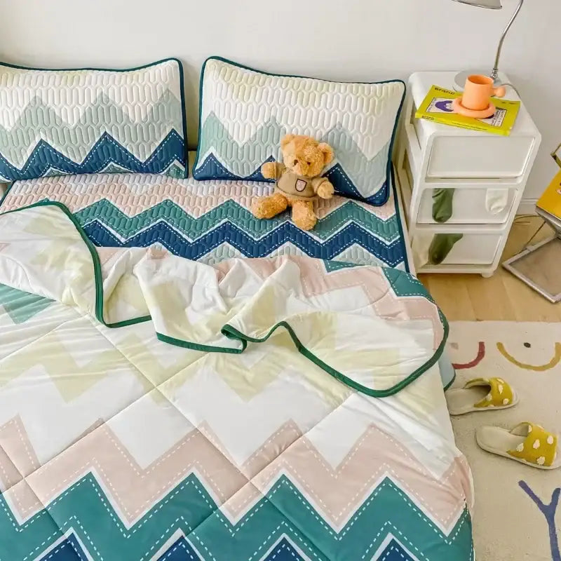 A cozy teal and cream zigzag quilt with stitched edges in the decorbites cool summer blanket set