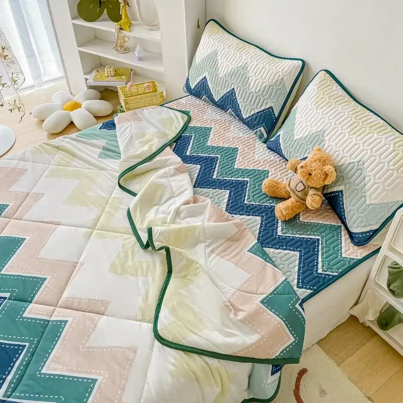 A cozy teal and cream zigzag decorbites cool summer blanket set with stitched edges and matching pillowcases