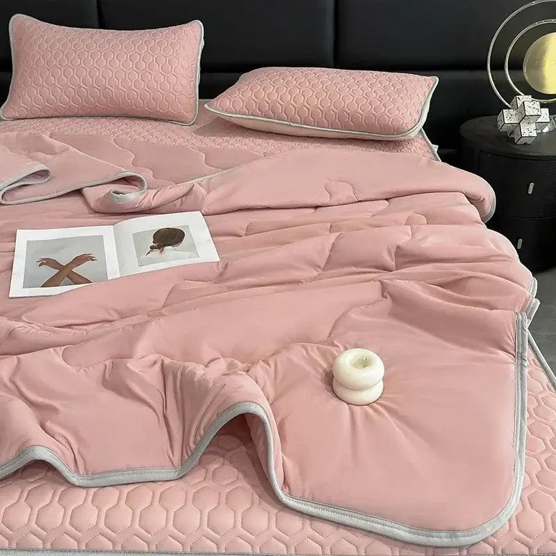 Pink quilted bedspread with soft plush texture and gray piping part of the decorbites cool summer blanket set