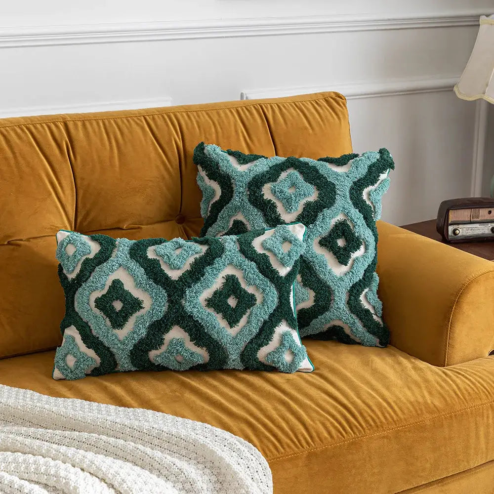 Two plush teal and dark green boho tufted pillow covers on a mustard yellow velvet sofa for decorbites boho decor