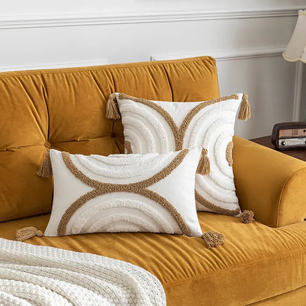 White rectangular decorbites boho tufted pillow covers with beige embroidery and tassels on mustard yellow velvet sofa