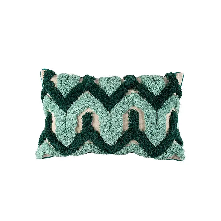 A plush rectangular cushion case with teal and dark green decorbites geometric embroidery tassel pattern and cream accents