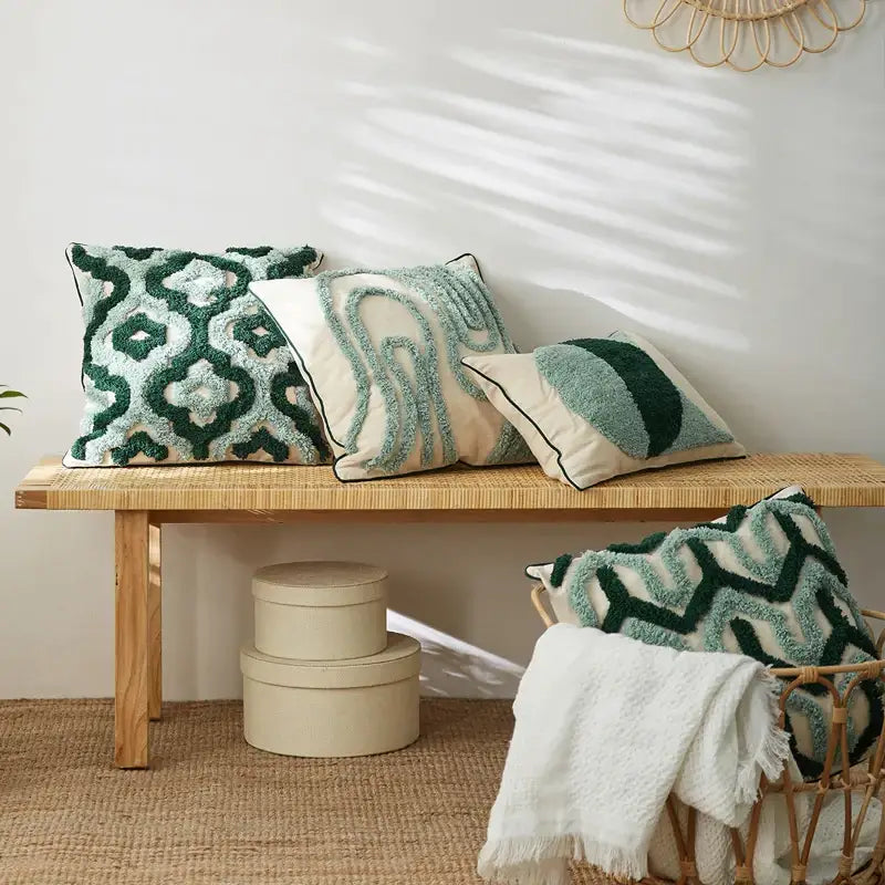 Three textured teal and dark green cushion cases with decorbites geometric embroidery tassel on woven bench decor
