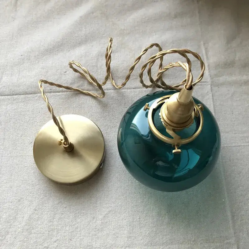 Teal glass ball pendant light with brass hardware and twisted cord by decorbites ideal for bedroom pendant light decor