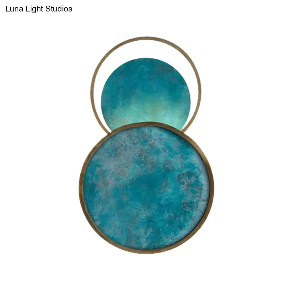 Modern abstract teal and gold blue glass led sconce with warm white light and overlapping circular textured discs