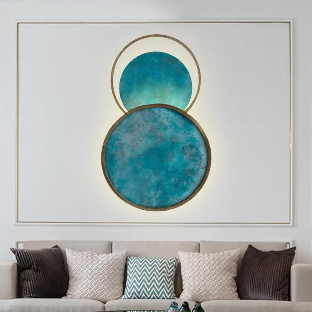 Modern abstract teal and gold blue glass led sconce with warm white light featuring textured overlapping circular panels