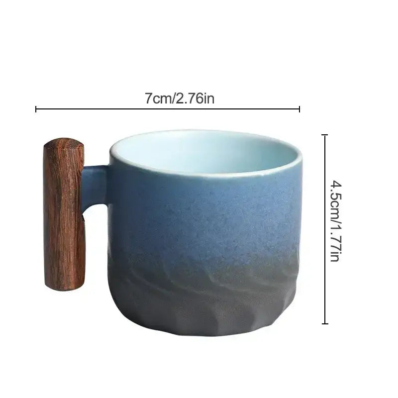 Teal and black ceramic coffee cup with blue gradient glaze and wooden handle for kitchen use