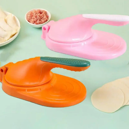 Pink and orange plastic dumpling skin maker with green textured handles and dough press tool for kitchen use