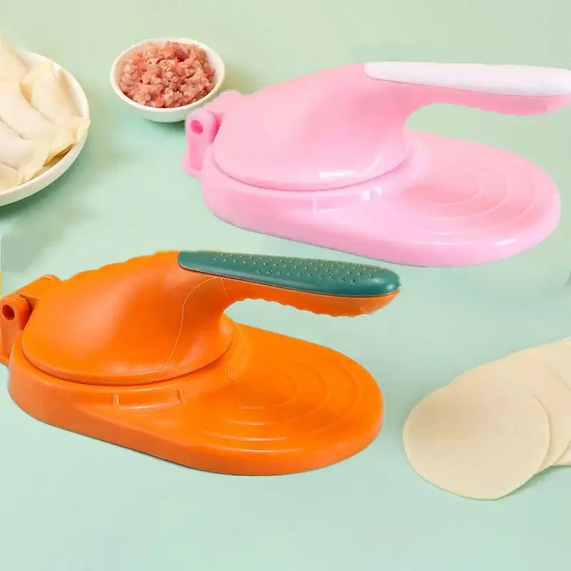 Pink and orange plastic dumpling skin maker with green textured handles and dough press tool for kitchen use