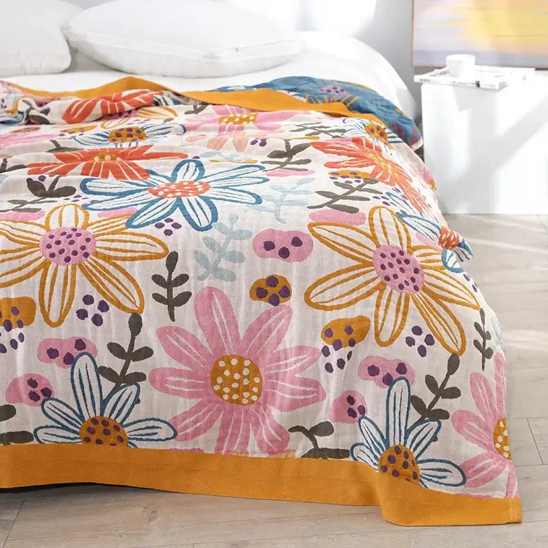A soft lightweight cotton gauze summer blanket with vibrant floral pattern on cream background for decorbites geometric cotton use