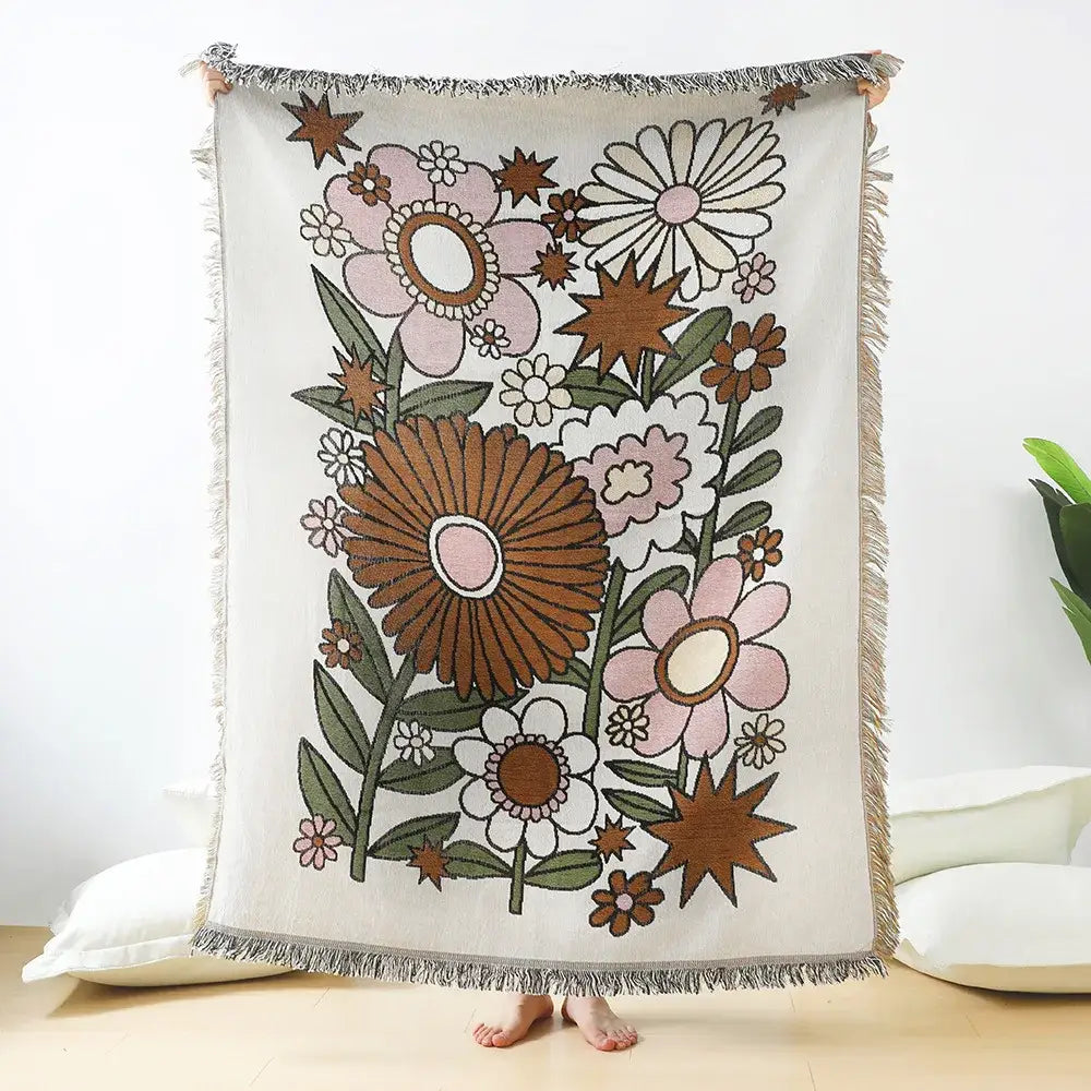 A cozy cream-colored decorbites daisy pattern woven throw blanket with vibrant floral motifs for living room decor
