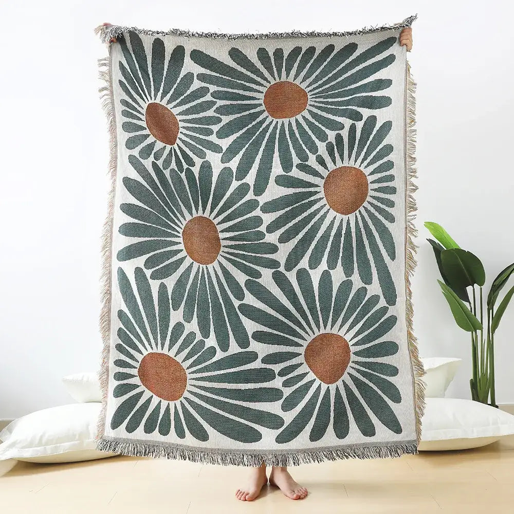 Cozy cream-colored throw blanket with bold teal and tan daisy pattern woven and soft fringed edges for decorbites decor