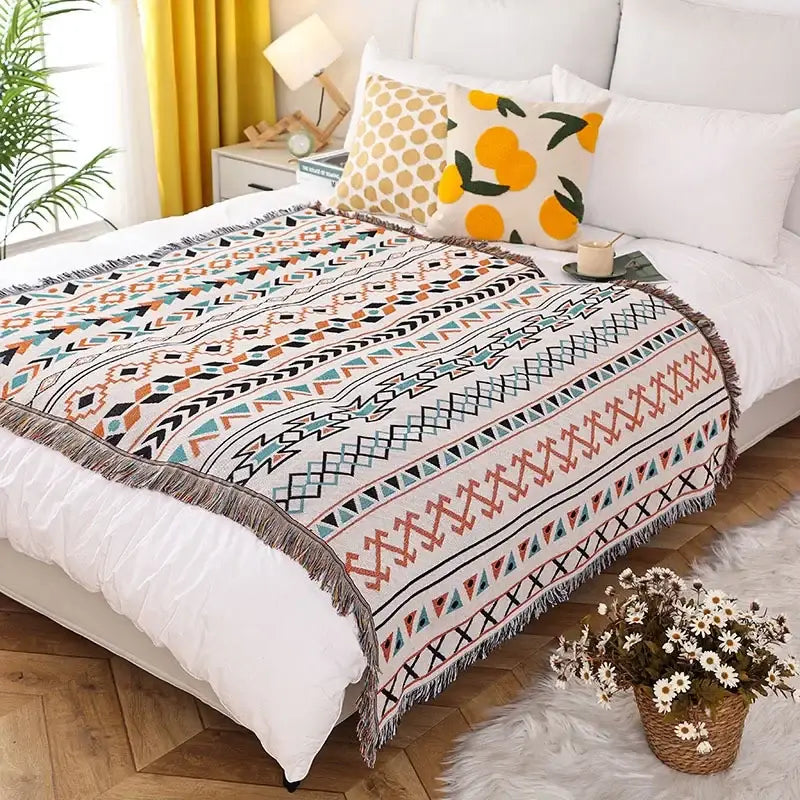 Teal tiger knitted nordic outdoor sofa blanket with vibrant geometric pattern and fringed edges on cream background