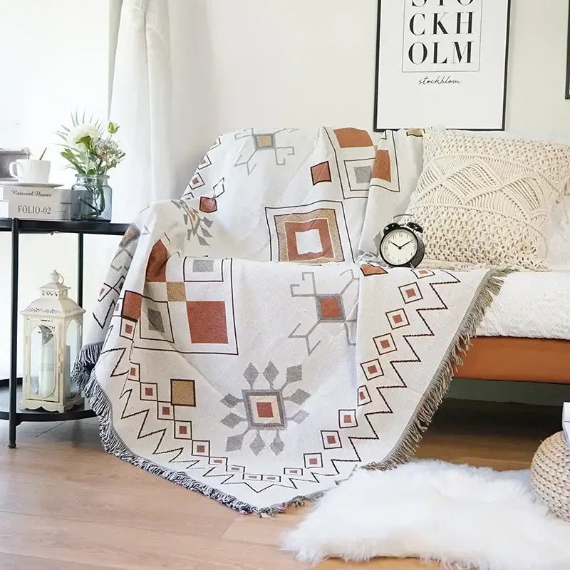 A cozy off-white decorbites knitted nordic outdoor sofa throw with geometric earthy tones and fringed edges