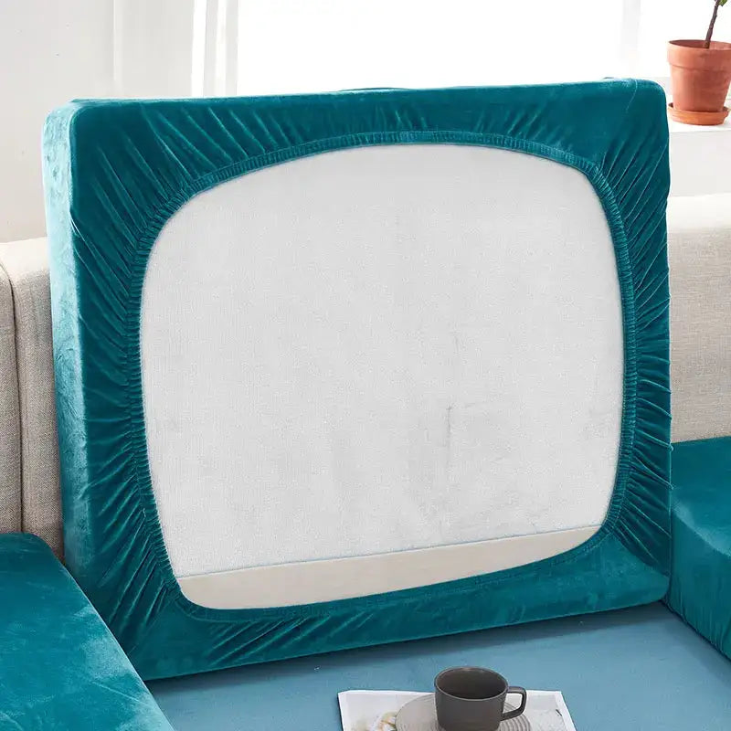 Teal velvet stretch sofa cushion cover with elasticated edge fitting snugly over the backrest for living room furniture protection