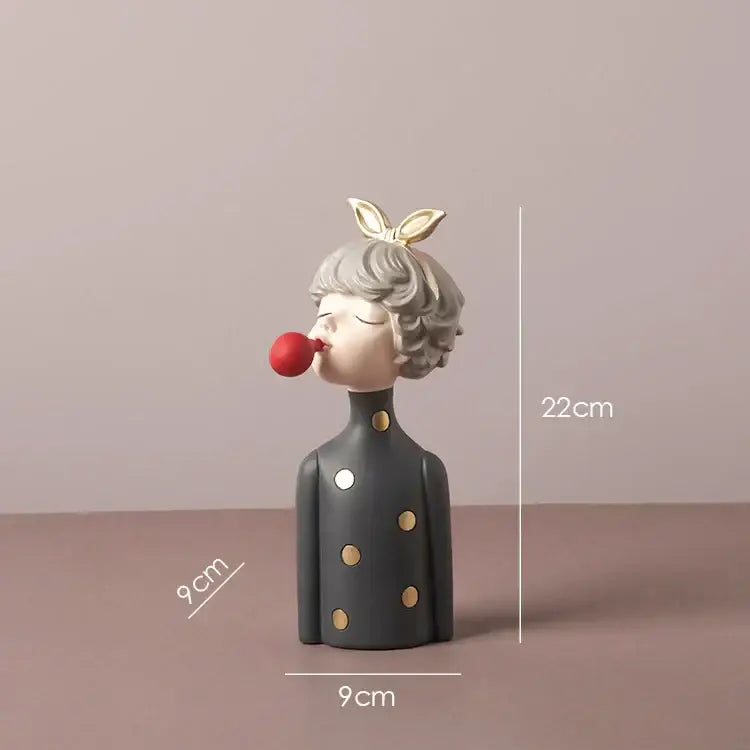 A gray ceramic bowknot girl resin figurine with gold polka dots and bunny ears blowing red bubblegum on a gold tray