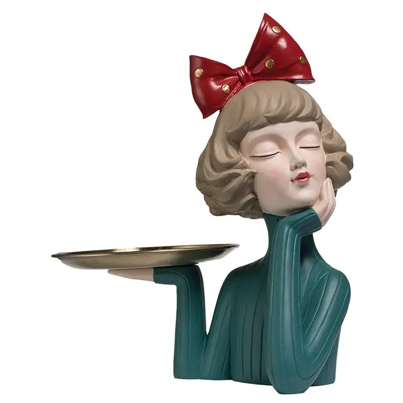 Teal bowknot girl resin figurine with blonde curls and red bow for bedroom decor by decorbites on a gold tray