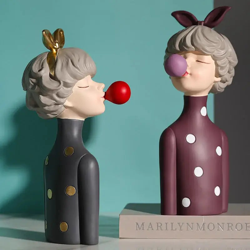Two stylized bowknot girl resin figurines in teal and white polka dot dresses with bubblegum on gold tray decorbites bowknot girl