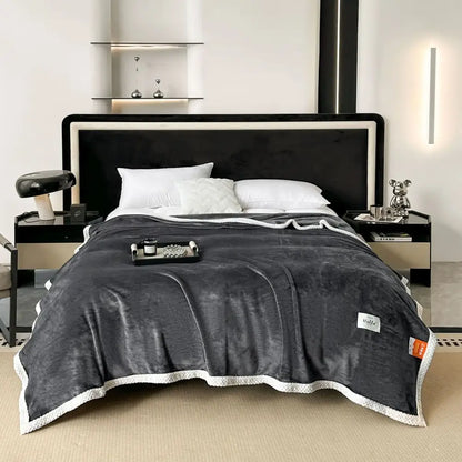 Dark gray plush throw blanket with white textured border and woven label cozy flannel nap blanket for bedroom use