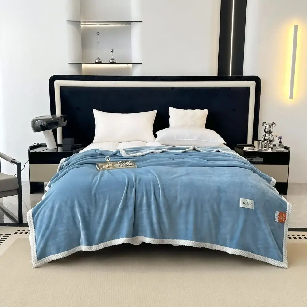 A light blue cozy flannel nap blanket with white textured border and subtle stitching perfect for bedroom use