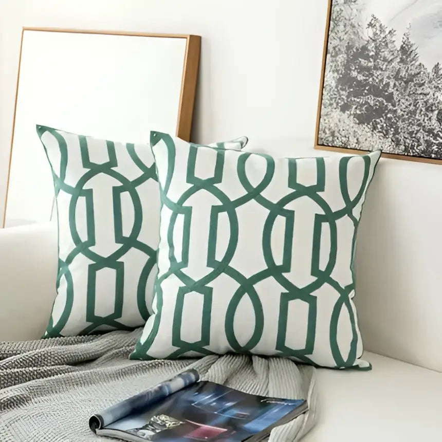 Teal and white embroidered geometric floral cushion cover with green and white geometric patterned throw pillows for living room