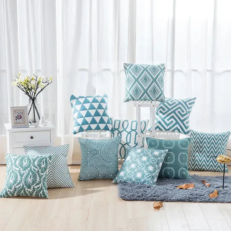 Set of teal and white geometric embroidered cushion covers featuring blue geometric decorbites patterns for living room decor