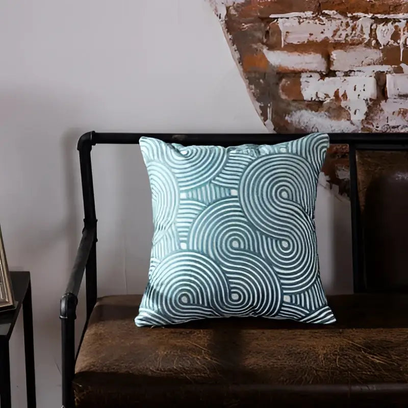 A light blue cushion cover with white concentric circles featuring blue geometric embroidered decorbites design