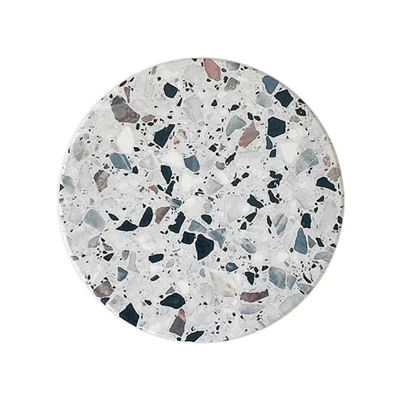 Circular terrazzo decorbites diatomite coaster with white black gray and muted pink speckled pattern for dining use