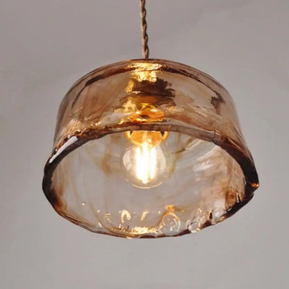 Hand-blown amber glass pendant light with warm textured finish and artisanal imperfections for dining room decorbites amber glass