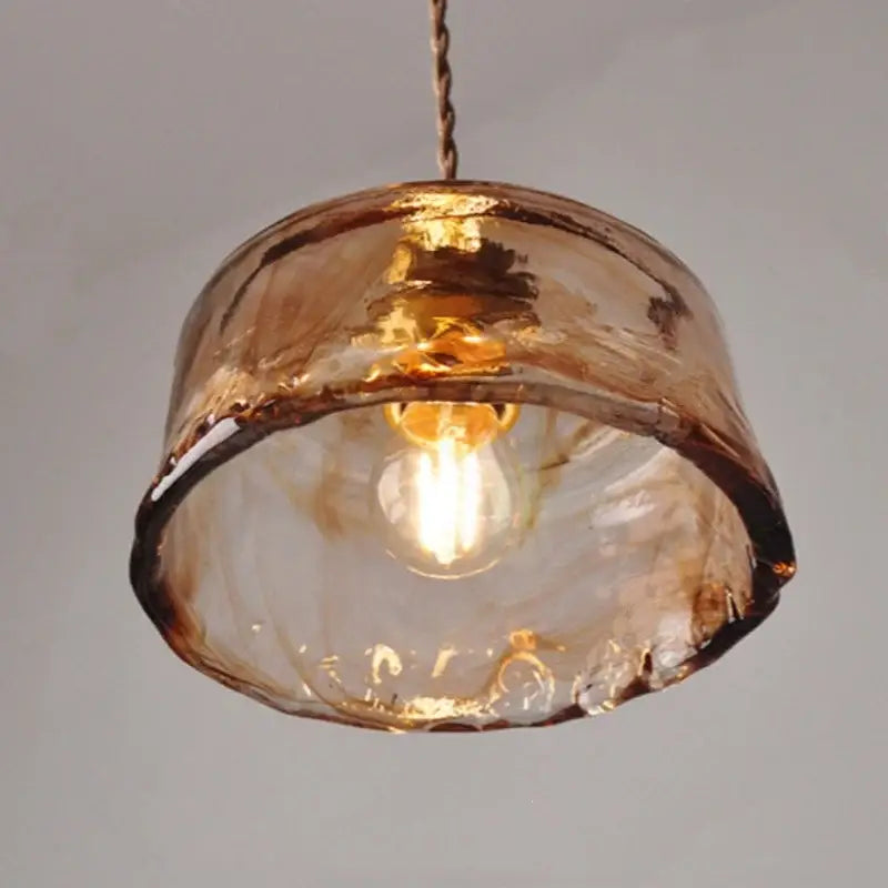Hand-blown amber glass pendant light with warm textured finish and artisanal imperfections for dining room decorbites amber glass