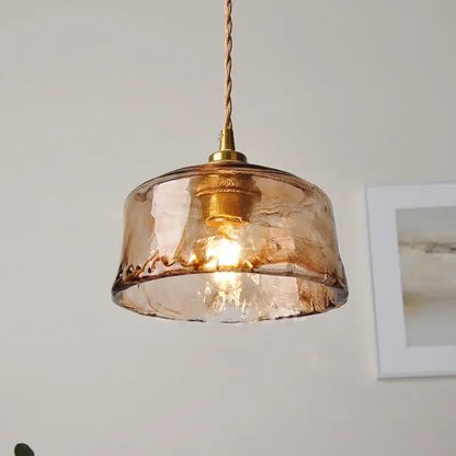 A warm amber glass pendant light with textured hand-blown finish and brass hardware for dining room decorbites amber glass