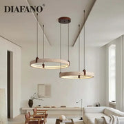 Two circular pendant lights with textured beige concrete finish and warm led lighting decorbites cave stone chandelier
