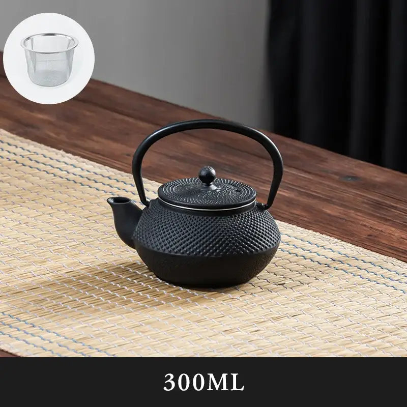 Textured black cast iron tea pot with dimpled surface and embossed lid designed for kitchen steeper use