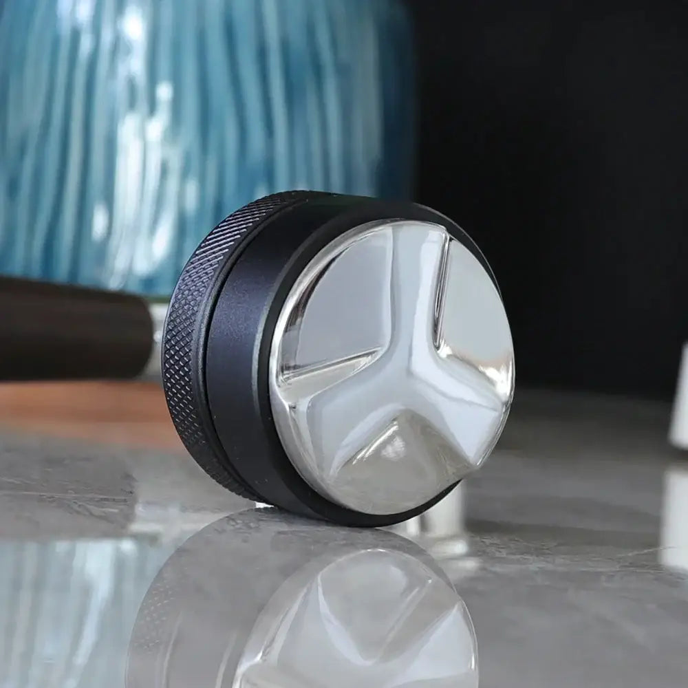 Silver and black espresso distribution tool with a textured grip ring for precise espresso distribution use