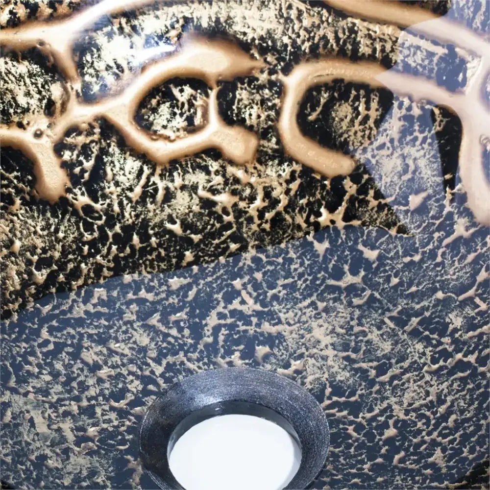 Textured black and gold glass wash basin with circular drain included in a bathroom waterfall faucet basin set