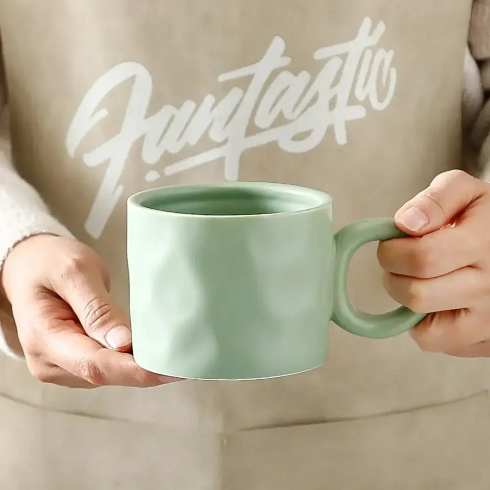 Matte mint green textured ceramic coffee mug with matching handle for kitchen use