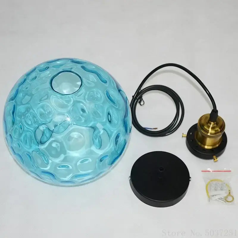 Textured blue glass ball pendant light with brass hardware and black mounting plate for dining room decorbites blue glass