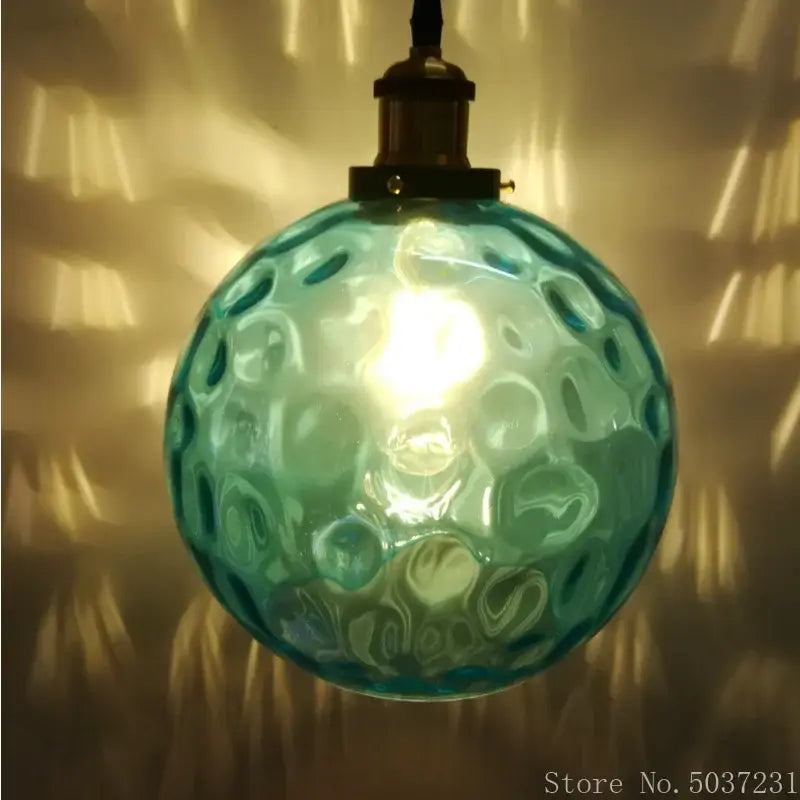 Teal glass ball pendant light with textured bubble surface and brass fixture for dining room decorbites blue glass style