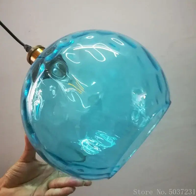 Textured blue glass ball pendant light with faceted surface and brass fixture for dining room decorbites blue glass decor