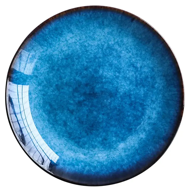 Glossy blue ceramic dinner plate with dark brown rim and speckled texture from decorbites dinner plate set