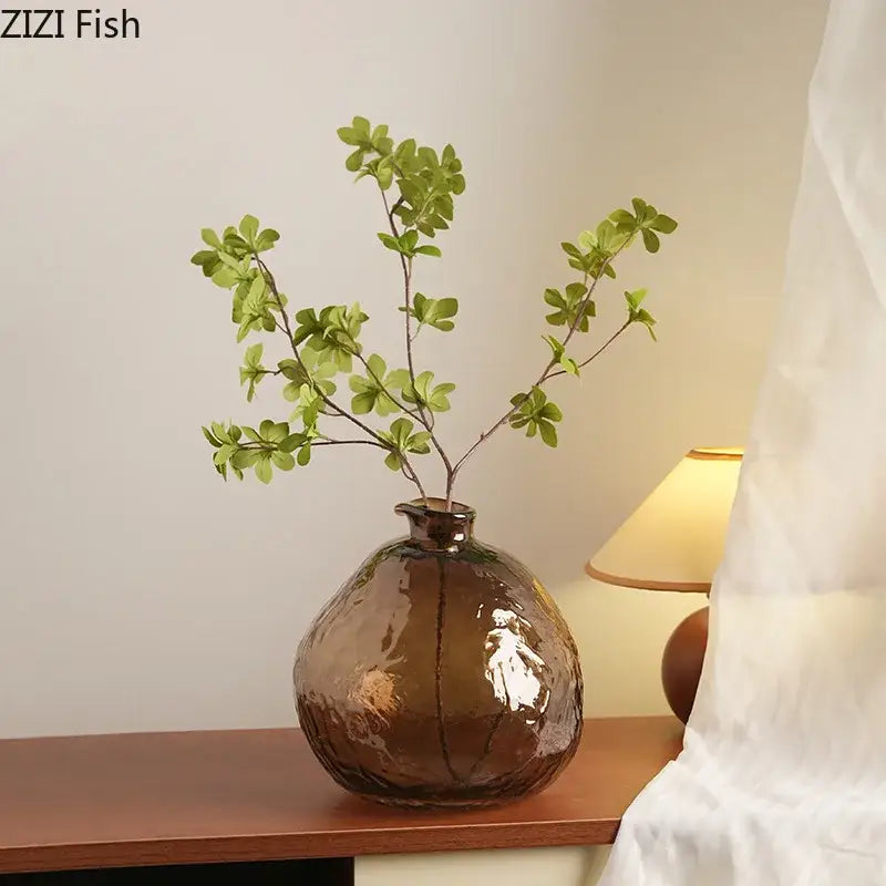 Textured brown glass vase with narrow neck holding artificial green leafy branches for decorbites brown glass decor