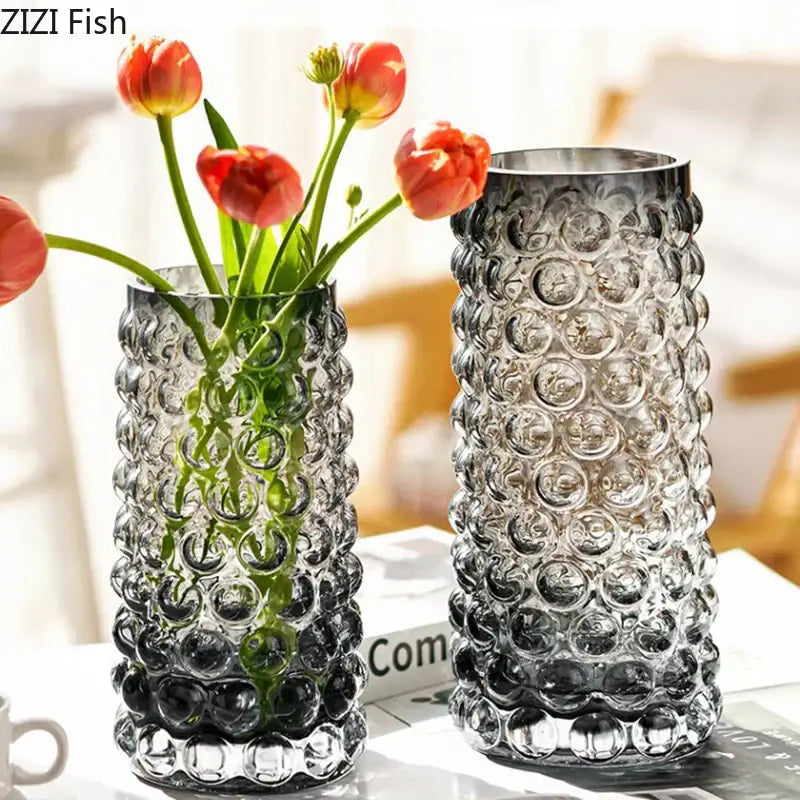 Two textured bubble glass hydroponics plant pots with orange tulips and one empty for living room table use